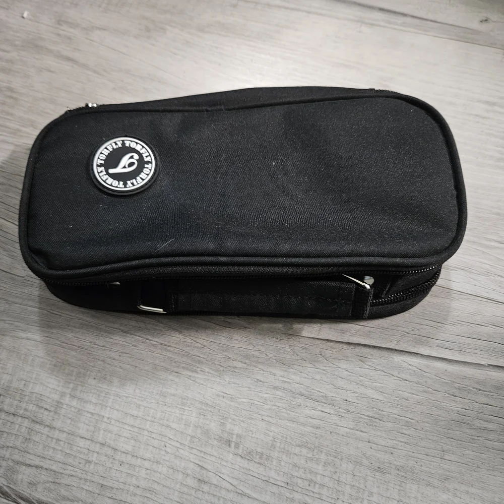 Torfly pencil case. Black with 2 zipper pouches and handle. Torly logo on front.